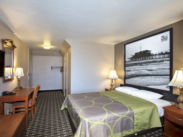 A hotel room with a bed, desk, and chair.